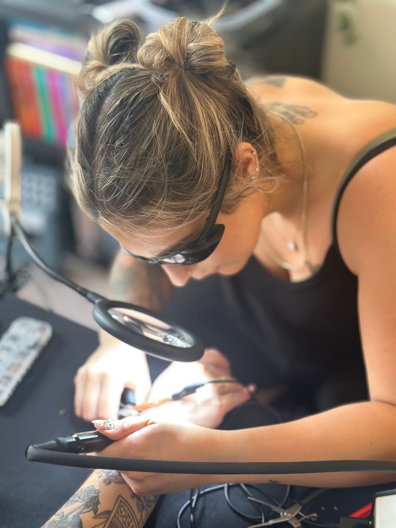 Jenna welding a bracelet onto a customer's wrist