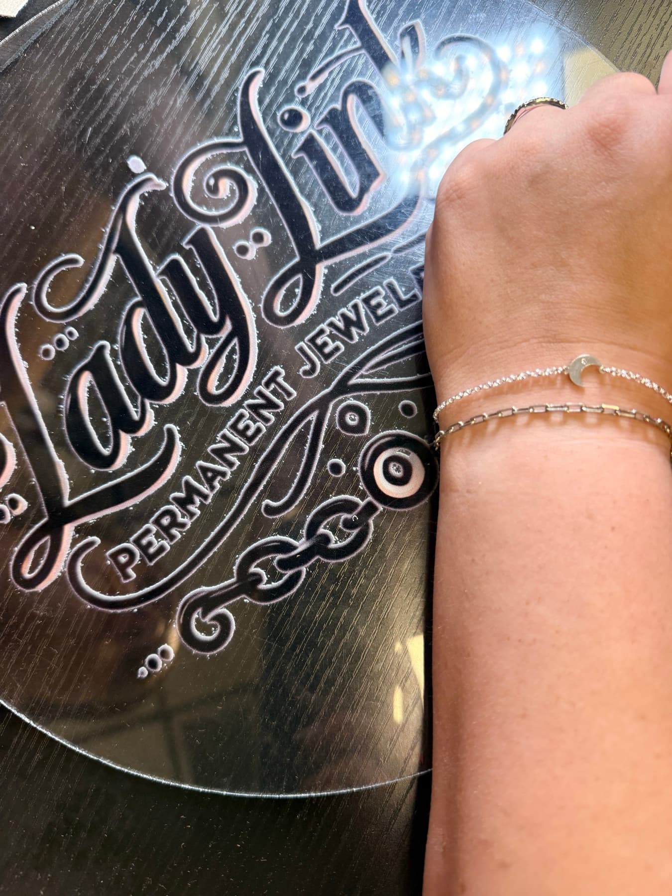 Two silver bracelets, one with a moon charm